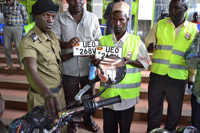 Police Superintendent for Clock Tower, Thomas Lutaaya hands over the first motorbike to Ssemakula Mansulu, a member of KCCBT.