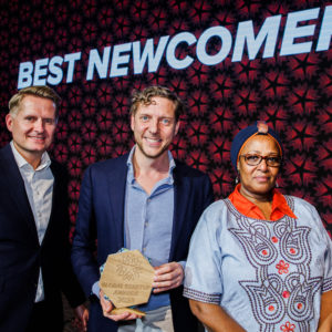 Emata CEO Bram van den Bosch (centre) accepts the award on stage in Copenhagen. On the right is the Ugandan ambassador to the Nordics and Baltics, and a Global Startup Award jury member to his left.