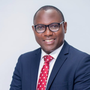Peter Ssenyange, CFO of PostBank Uganda (now Pearl Bank Uganda Ltd) and Uganda’s CFO of the Year 2025, poses confidently in a navy suit and red tie. His leadership philosophy—anchored in strategy, people empowerment, innovation, and value creation—reflects his belief that a great CFO is both a trusted advisor to the CEO and a custodian of sustainable growth.
