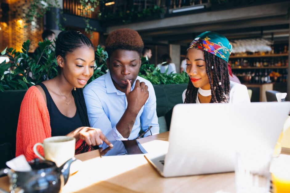 Gen Z professionals collaborating on a laptop and tablet in a modern office setting, reflecting changing workplace expectations and digital-driven career growth in Uganda.
