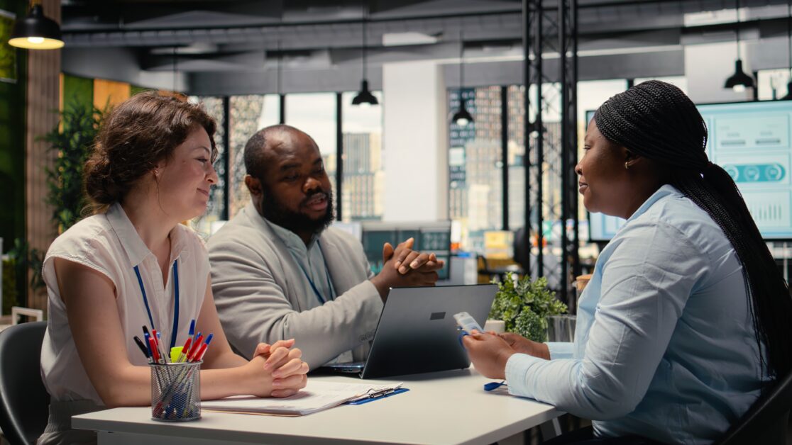 HR team issuing an employee ID security card to a new hire during onboarding, highlighting leadership and workplace culture’s role in talent retention.