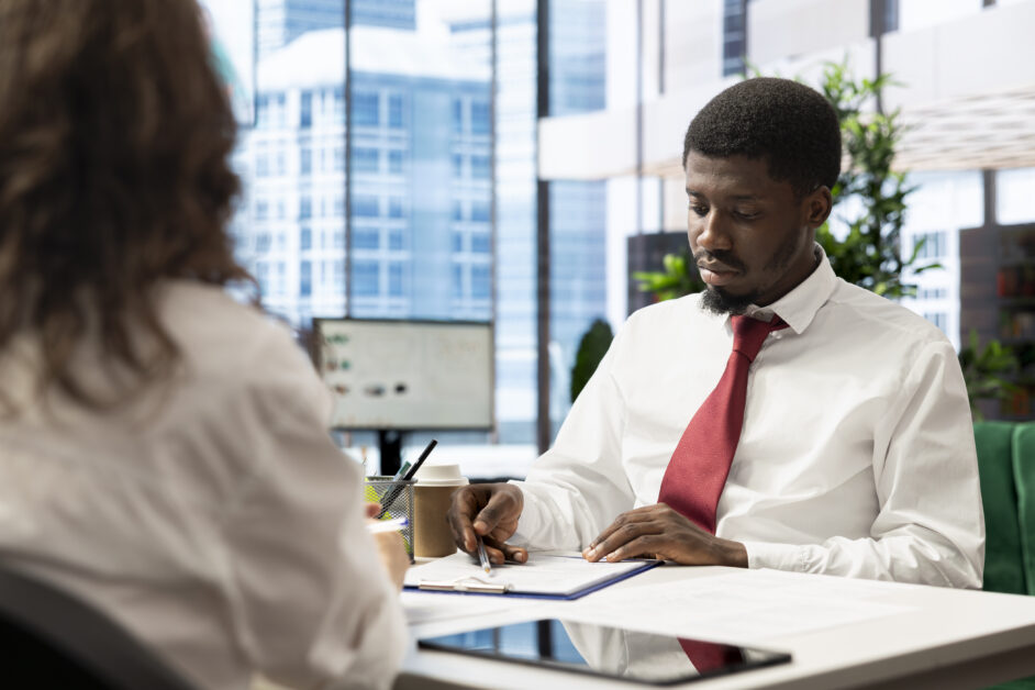 HR officer seated across from a departing employee during an exit interview, reflecting the growing conversation about why Ugandan leaders leave organisations beyond salary concerns.